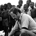 man examining something on the ground in a crowd of people