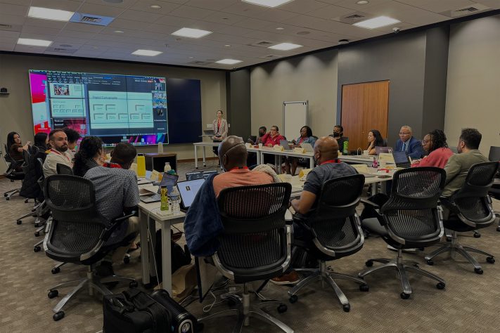 a room full of people seated at tables and attending a presentation, which takes place in the background. Featured image for Advancing HBCU Scholarship, Diversifying Digital Publishing.