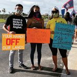 protesters for indigenous rights posing with signs. Featured image for the publication Imperial Unsettling.