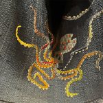 a bright embroidered design on dark fabric