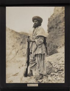 a man in traditional attire and turban stands on rocky terrain, holding a rifle. The image is titled "Mahsooli Raider" at the bottom.
