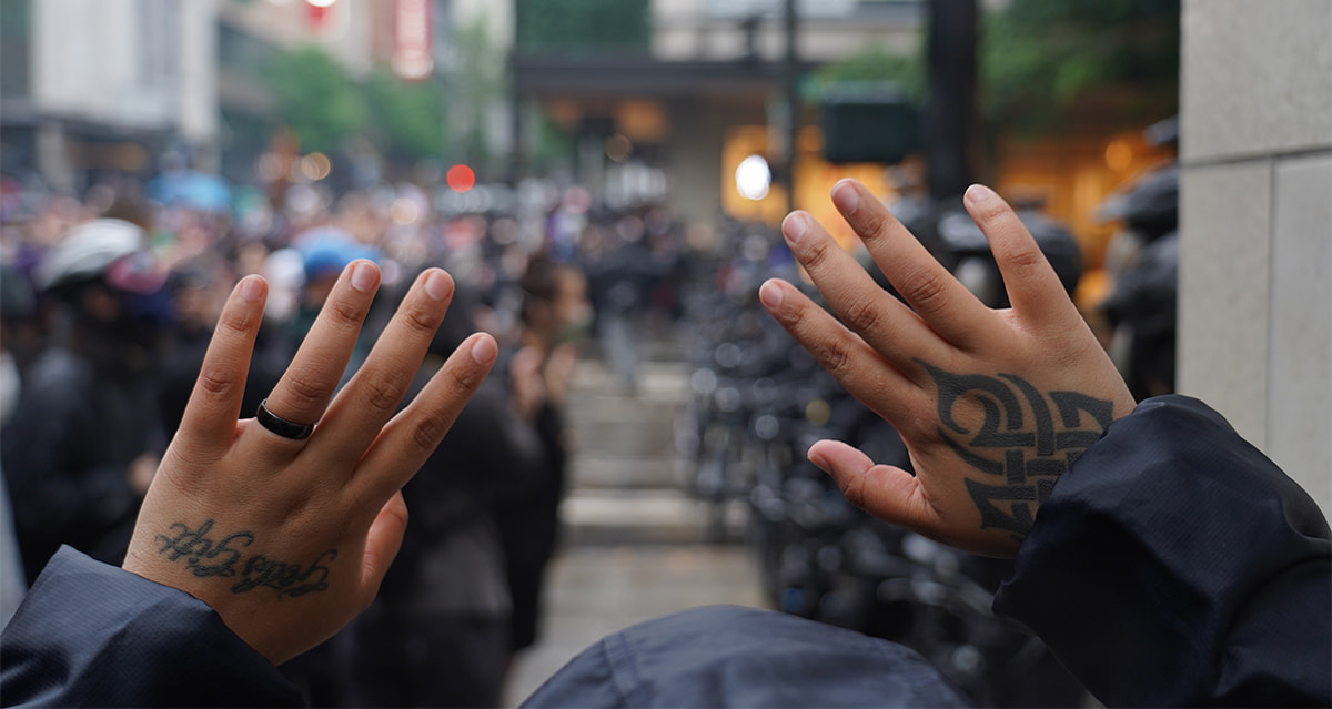 person with raised hands at a demonstration