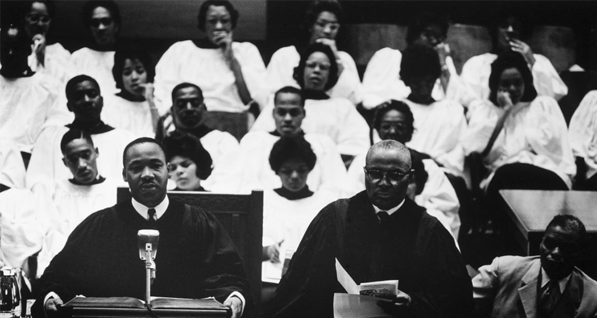 Dr. Martin Luther King, Jr. and Reverend Martin Luther King, Sr. standing at a pulpit in a church