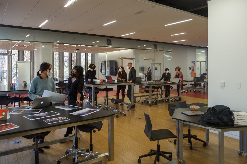 people collaborate in open studio at tables