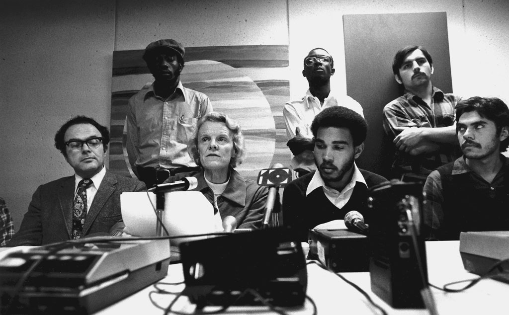 Students and administrators in front of bank of microphones