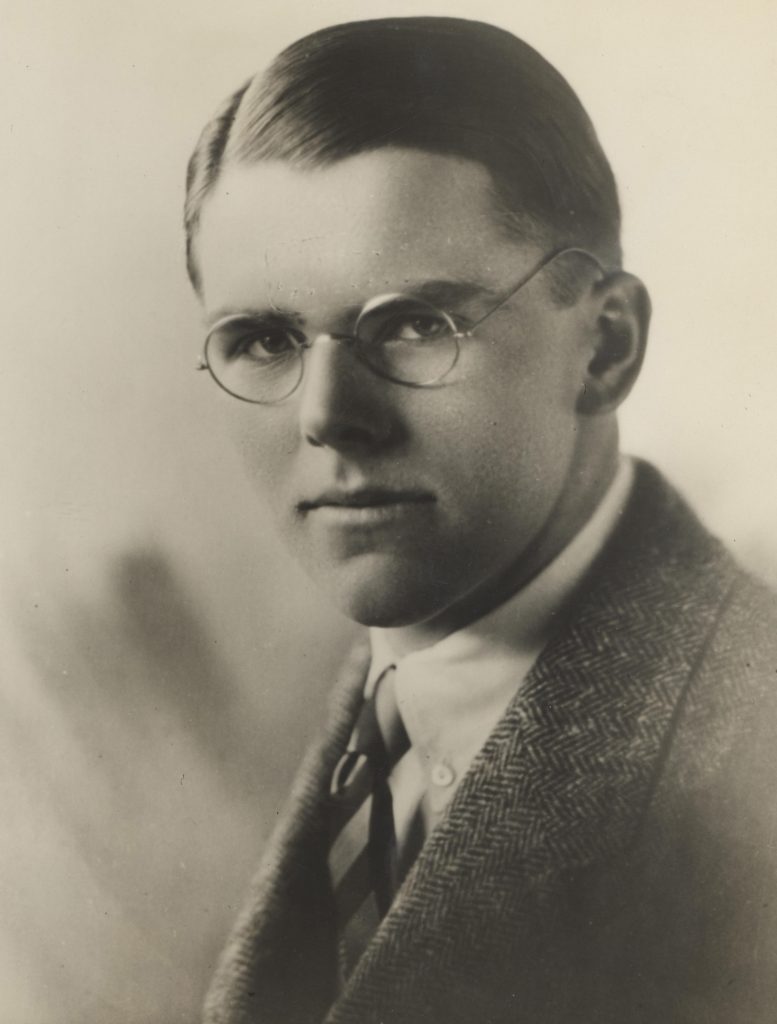 black and white image of young man with spectacles and suit