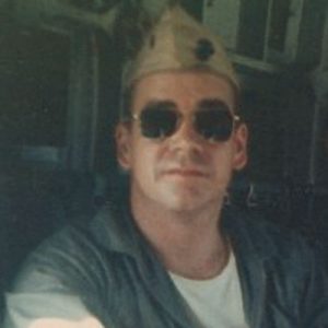 seated in military air transport. (1st Lieutenant, U.S. Marine Corps, 1964-1967. Killed in action, Nui Dang, Vietnam. 27 February, 1967) Photograph, circa 1966