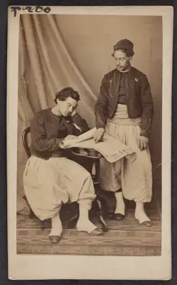 Cartes-de-visite were commonly traded among friends and visitors in the 1860s. The albums that collected and displayed these cards became a common fixture in Victorian parlors. Their relatively low cost contributed to the popularity of the format and its rapid adoption worldwide, which made portrait photographs accessible to a broader demographic. The cards also made the ideal way to remember loved ones fighting in foreign wars, making soldiers frequent clients at photography studios. Prior to the advent of mechanical reproduction of photographs, cartes-de-visite facilitated the dissemination and collection of portraits of prominent persons as an early form of celebrity culture. It is uncertain whether these photographs were given as personal portraits between familiars or as character types of ethnic groups serving in the French Army, which was also a common use of these carte-de-visite, akin to earlier costume album paintings.

All of these cartes-de-visite feature Zouave uniforms, yet only the one portraying Turcos was definitively photographed by a studio in Algiers. Part of the appeal of this cross-cultural uniform was how intentionally difficult it became to discern the ethnic origins of a soldier with certainty (though the titles tirailleurs and turcos often indicated troops of North African descent). Likewise, the popularity of Zouave soldiers — and the women who served as cantinières, or canteen keepers, and who sometimes fought alongside them in battle — spurred many French consumers and performers, including female burlesque dancers, to dress in Zouave costumes for studio portraits. Though a highly exoticizing use of regional fashion, the rising numbers of commercial portraits of civilians donning Zouave costumes attest to how these soldiers and the visual traces of colonization had infiltrated the popular imaginations of French consumers.