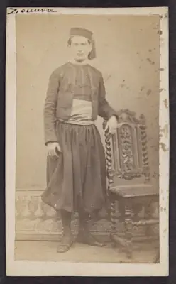 Cartes-de-visite were commonly traded among friends and visitors in the 1860s. The albums that collected and displayed these cards became a common fixture in Victorian parlors. Their relatively low cost contributed to the popularity of the format and its rapid adoption worldwide, which made portrait photographs accessible to a broader demographic. The cards also made the ideal way to remember loved ones fighting in foreign wars, making soldiers frequent clients at photography studios. Prior to the advent of mechanical reproduction of photographs, cartes-de-visite facilitated the dissemination and collection of portraits of prominent persons as an early form of celebrity culture. It is uncertain whether these photographs were given as personal portraits between familiars or as character types of ethnic groups serving in the French Army, which was also a common use of these carte-de-visite, akin to earlier costume album paintings.

All of these cartes-de-visite feature Zouave uniforms, yet only the one portraying Turcos was definitively photographed by a studio in Algiers. Part of the appeal of this cross-cultural uniform was how intentionally difficult it became to discern the ethnic origins of a soldier with certainty (though the titles tirailleurs and turcos often indicated troops of North African descent). Likewise, the popularity of Zouave soldiers — and the women who served as cantinières, or canteen keepers, and who sometimes fought alongside them in battle — spurred many French consumers and performers, including female burlesque dancers, to dress in Zouave costumes for studio portraits. Though a highly exoticizing use of regional fashion, the rising numbers of commercial portraits of civilians donning Zouave costumes attest to how these soldiers and the visual traces of colonization had infiltrated the popular imaginations of French consumers.