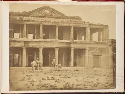 Photo of bones before a bombed out structure