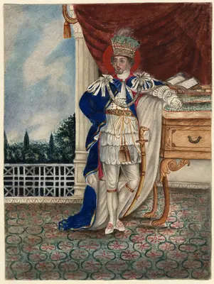 full-length portrait in crown, court dress, and Garter cloak, leaning against desk or table, drapery, column and view in background.