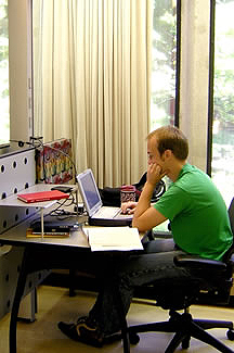 student at his computer in a study carrel